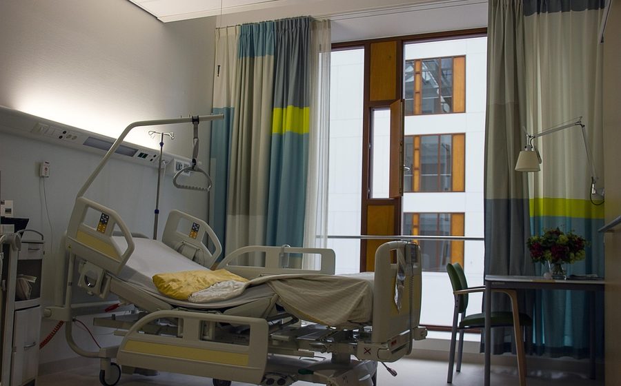 Empty hospital bed and waiting chair